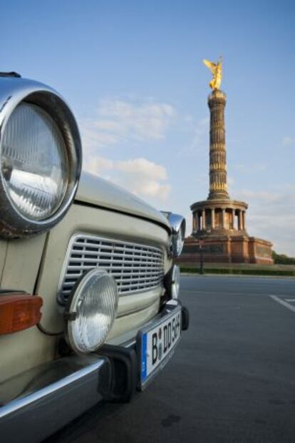 Un coche Trabant con la berlinesa Siegessäule al fondo.