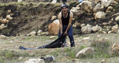 Un hombre ayuda a un palestino herido por los militares israelíes durante una manifestación en contra de las operaciones militares israelíes en la Franja de Gaza, en Naplusa, Cisjordania.