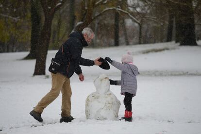 La nieve ofrece estas estampas. En Vitoria, una niña y su abuelo se afanan en levantar un muñeco de nieve.