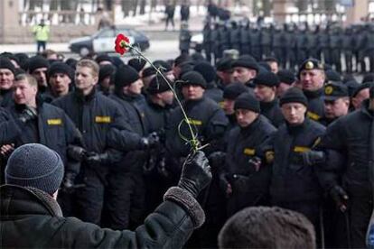 Un manifestante opositor muestra un clavel a decenas de policías en Minsk el 25 de marzo.