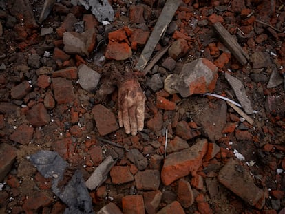 Una mano asoma entre los restos de una casa destrozada en Kupiansk por un ataque de Rusia el lunes.