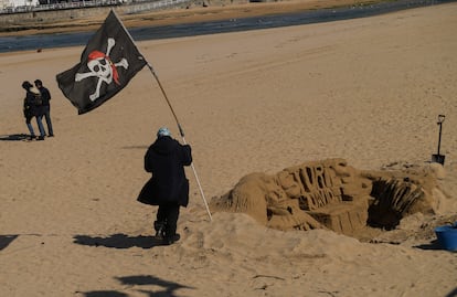 Una persona pasaba el domingo junto a una escultura de arena en la playa de San Lorenzo, en Gijón.