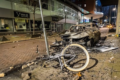 Un coche y una bicicleta calcinados tras los disturbios en Róterdam del 20 de noviembre.