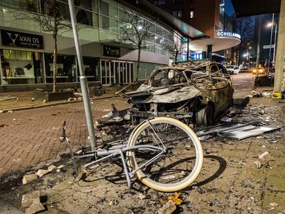 Un coche y una bicicleta calcinados tras los disturbios en Róterdam del 20 de noviembre.