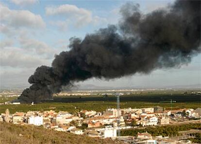 La espesa columna de humo, en la mañana de ayer, sobre la comarca de La Ribera. En primer plano, la localidad de Manuel.