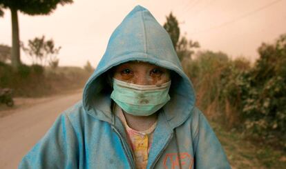 Una mujer cubierta de cenizas durante la erupción del volcán Sinabung, en Sumatra (Indonesia).