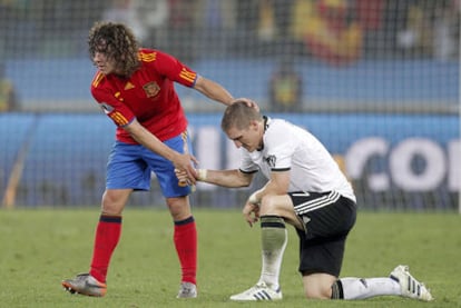 Puyol consuela a Schweinsteiger tras el partido.