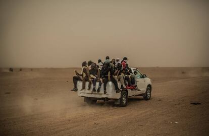 Un grupo de migrantes en la parte trasera de una camioneta atraviesa el desierto de N&iacute;ger en direcci&oacute;n Libia.