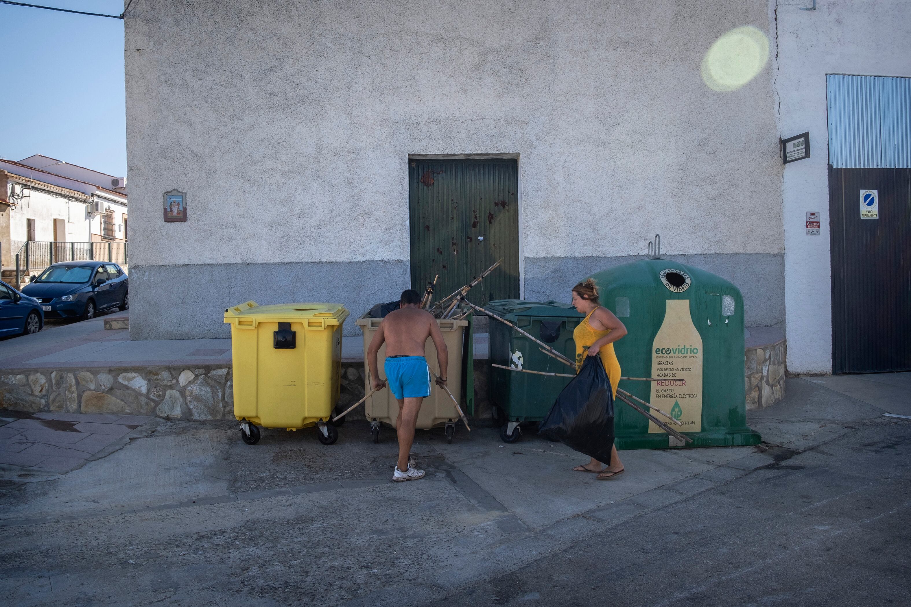 Dos vecinos de El Garrobo junto a varios contenedores.