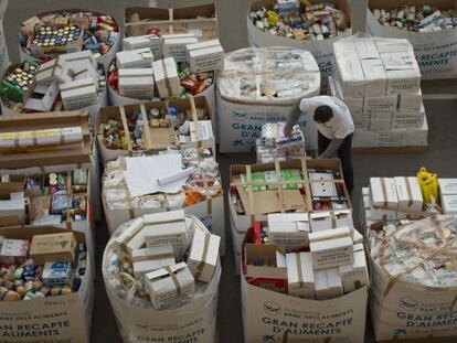 Un voluntario ordena los contenedores de cartón en el almacén del Banco de los Alimentos, en Barcelona.