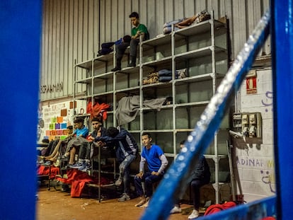 Varios niños marroquíes duermen en estanterías dentro de una nave industrial del Tarajal, Ceuta, el pasado martes.