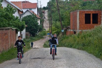 Niños montan en bicicleta por las calles de Hade, donde muchas de sus casas se han quedado vacías por los desplazamientos a otras áreas.