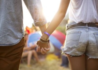 Una pareja se da la mano en un festival de música.