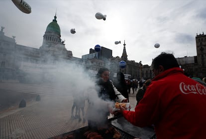 Una manifestante compra un choripán afuera del Congreso Nacional, durante la protesta.