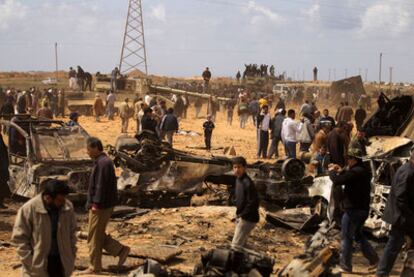 Multitud de curiosos observan los restos de las fuerzas de Gadafi, en Al Wayfiyah, cerca de Bengasi, tras un ataque de aviones aliados.