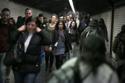 Pasajeros y congresistas que se dirigeb al Mobile World Congress caminan por un pasillo del transbordo entre la L3 y los ferrocarriles en plaza España.