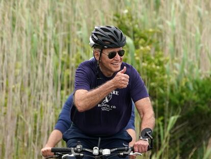 El presidente Joe Biden monta en bicicleta por un parque en Delaware.