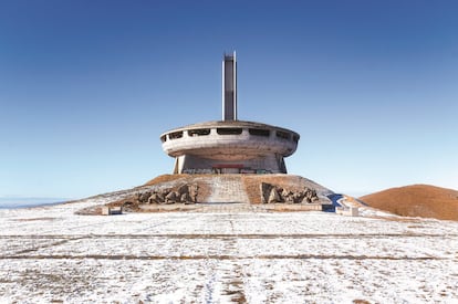 Según explica el fotógrafo, el edificio abandonado que se erige sobre el monte Buzludja, a 1.432 metros de altitud, se inauguró en 1981 para conmemorar la liberación de Bulgaria del yugo otomano (1891) y de la dominación nazi (1944). También sirvió como cuartel general simbólico para el partido comunista búlgaro. Miles de voluntarios participaron en su construcción, que costó unos 14 millones de levs búlgaros (unos ocho millones de dólares). Hasta mediados de los noventa, el monumento estuvo protegido por guardias, según se informó Robroek, que precisa que “su enorme tejado, antaño completamente de cobre, fue totalmente saqueado al día siguiente de marcharse los guardias”. Poco después, la estructura ya se encontraba en un estado “lamentable” a causa del robo de sus elementos.