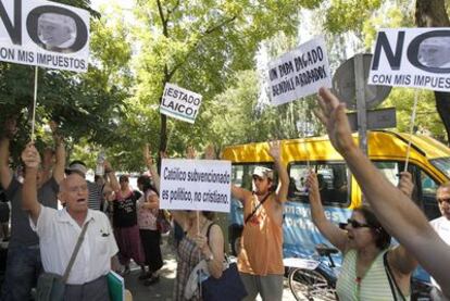 Peregrinos se cruzan con indignados desempleados que protestan ante la sede del Consorcio de Transportes