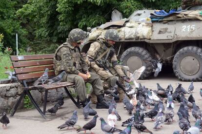 Soldados ucranios dan de comer a las palomas cerca del ayuntamiento de Salvyansk, Ucrania.