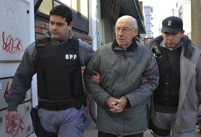 El exdictador argentino Jorge Rafael Videla es escoltado a una sala de audiencias el 13 de julio de 2012, en Buenos Aires. Videla murió por causas naturales el viernes 17 de mayo de 2013, mientras cumplía cadena perpetua en la prisión de Marcos Paz.