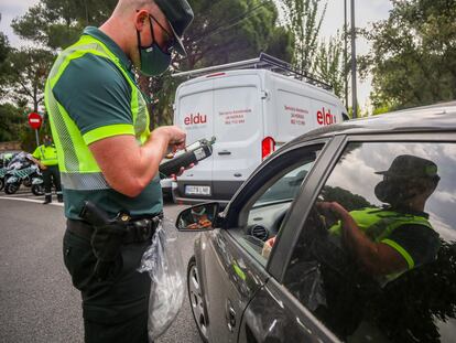 Un policía para a unos coches para someter a pruebas de control de consumo de drogas y alcohol a los conductores durante la presentación de una nueva campaña de la DGT, este miércoles.