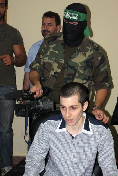 Gilad Shalit, en la frontera egipcia, con un miembro de Hamás detrás.