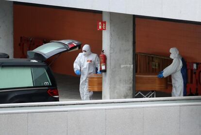 Dos operarios trasladan un féretro en el hospital Puerta de Hierro de Majadahonda (Madrid), el 20 de marzo.