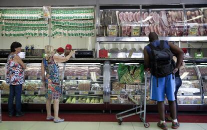 Clientes compram carne em açougue de São Paulo.