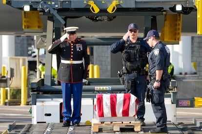 Marine First Sgt. Timothy La Sage, left, and Port Authority police officers salute as the remains of retired Marine Capt. Grady Kurpasi are transferred from a Turkish airlines plane at New York's John F. Kennedy International Airport.