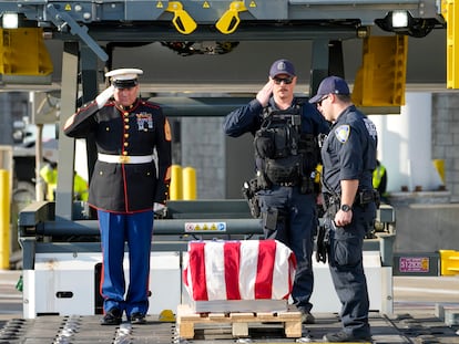 Marine First Sgt. Timothy La Sage, left, and Port Authority police officers salute as the remains of retired Marine Capt. Grady Kurpasi are transferred from a Turkish airlines plane at New York's John F. Kennedy International Airport.