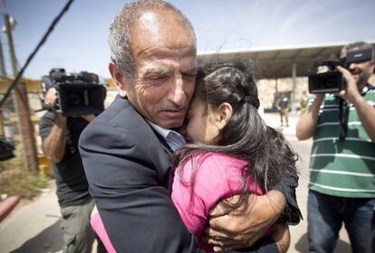 La adolescente se abraza a su padre en el puesto de control de Jabara. 