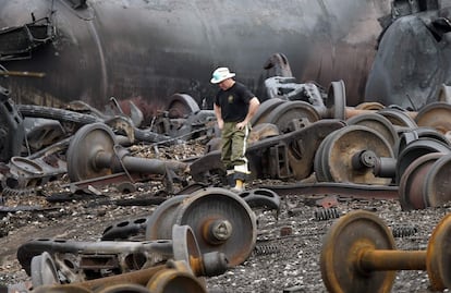 Un policía investiga entre los restos del tren siniestrado, 9 de julio de 2013. El ministro canadiense de Transportes, Denis Lebel, ha asegurado que el tren pasó una inspección el día anterior al siniestro en Montreal y que no se encontró ninguna deficiencia.