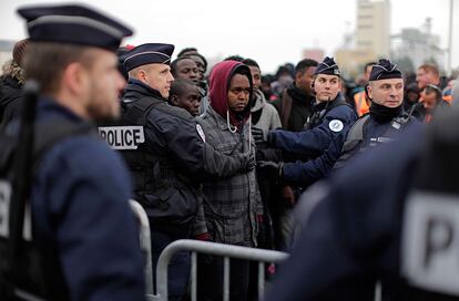 La policía francesa controla el flujo de migrantes antes de ser registrados para su evacuación del campamento de Calais (Francia).