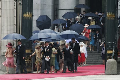 Los invitados se protegen con paraguas de la lluvia al final de la ceremonia.