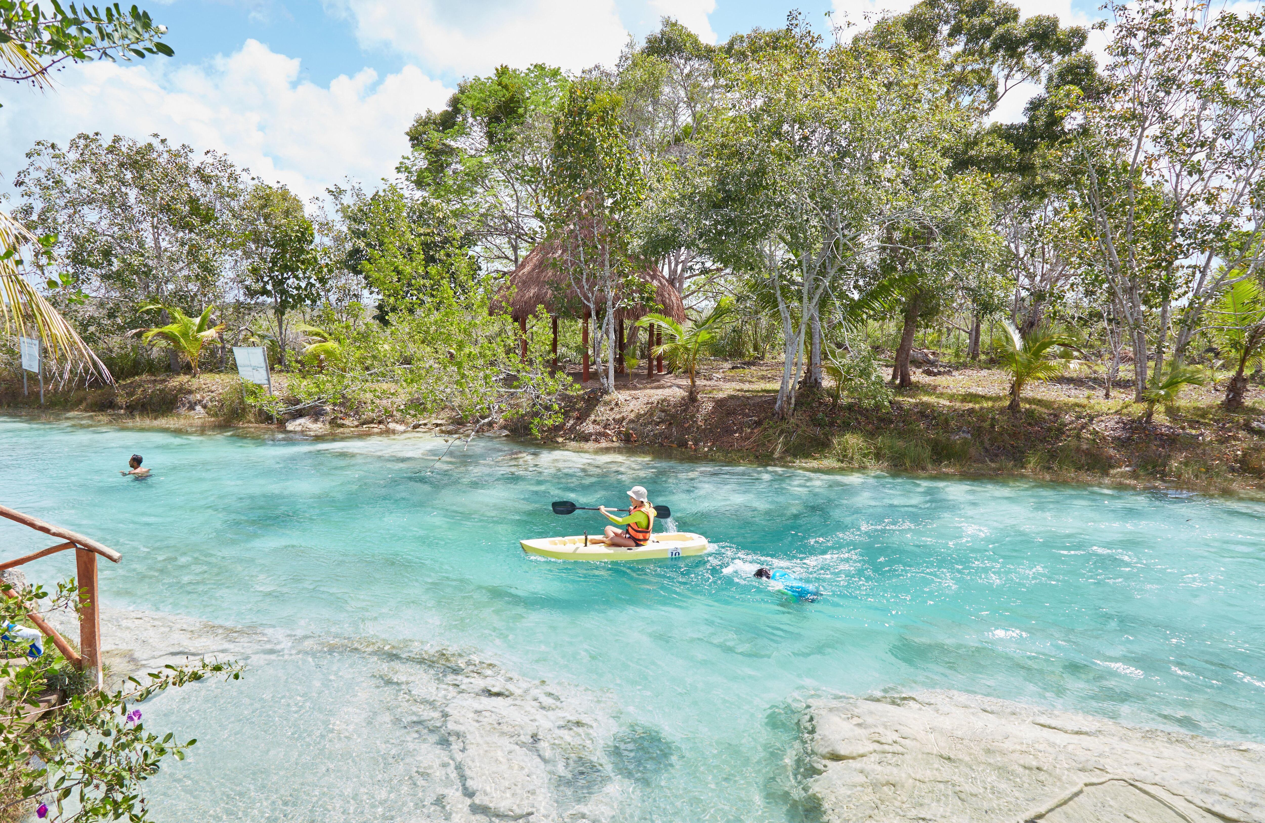 Un bañista y un kayak en los rápidos de Bacalar (México).