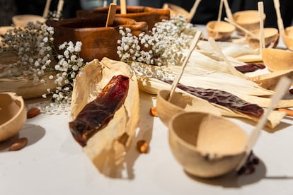 Jícaras, hojas de maíz, chiles, flores y salsas en la mesa del pasado.