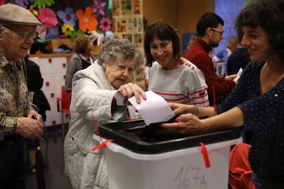 Una mujer introduce su voto en una urna de un centro electoral de Barcelona.