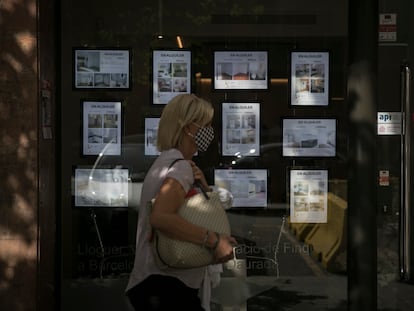 Una mujer pasa ante el escaparate de una inmobiliaria en Barcelona, el mes pasado.