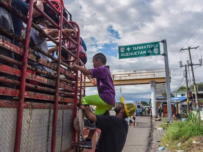 Migrantes hondureños se suben a un camión con destino a Estados Unidos. 