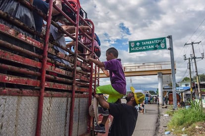 Migrantes hondureños se suben a un camión con destino a Estados Unidos. 