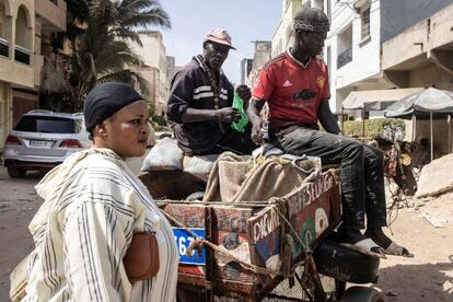 Pathe, un conductor de carruajes de caballos, vende pescado a una clienta en las calles del barrio de Yoff, en Dakar. Alphonse Sene, jefe de un departamento del ministerio de Agricultura, calcula que hay 7.000 conductores de carretas en la capital senegalesa. Y el número va en aumento.