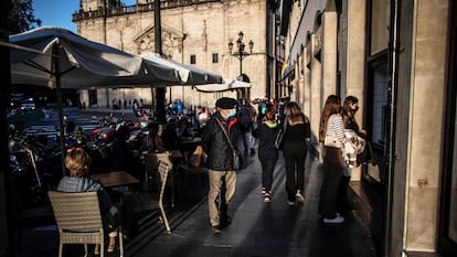 Varias personas pasean y disfrutan de las terrazas frente a la iglesia de San Nicolás, en Bilbao.