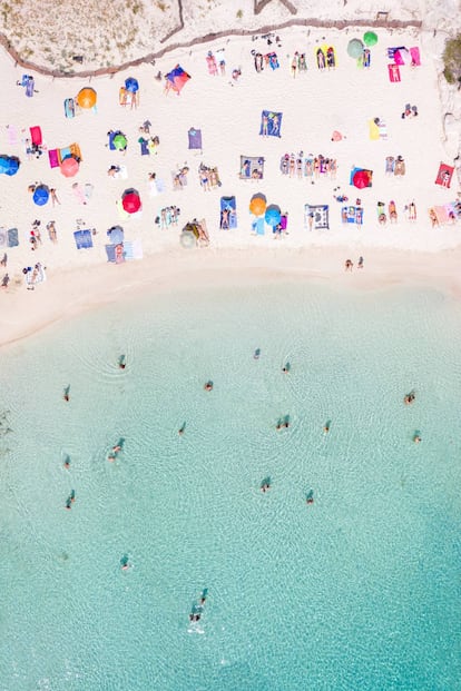 Vista aérea de unos cuantos bañistas en Cala Macarelleta en Menorca.