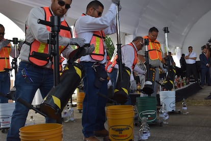 Personal de la policía federal mexicana y el consejo regulador de tequila destruyen botellas adulteradas. 