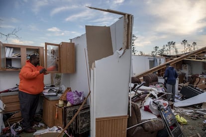 Un hombre recupera artículos personales de su hogar devastado tras el paso de un tornado en un vecindario en Beauregard, en Alabama (EE UU).