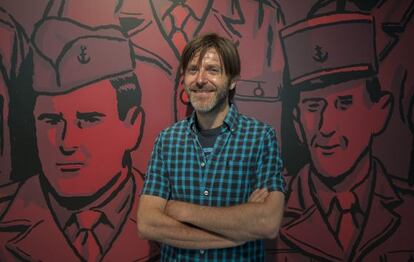 Paco Roca, junto a una ampliación de una ilustración de su libro 'Los surcos del azar', en una exposición en Valencia.