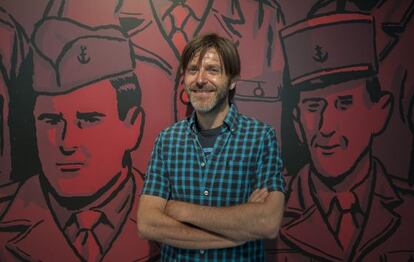 Paco Roca, junto a una ampliaci&oacute;n de una ilustraci&oacute;n de su libro &#039;Los surcos del azar&#039;, en una exposici&oacute;n en Valencia.
    
 