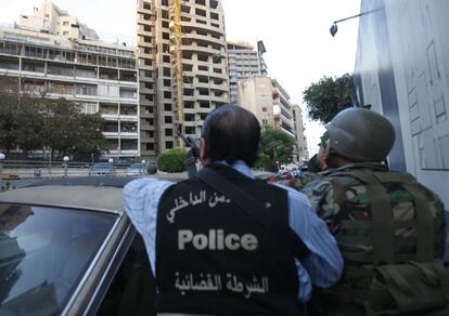 Un policía y un militar vigilan el edificio de apartamentos donde se atrincheró uno de los sirios que había participado en las escaramuzas entre facciones sirias.