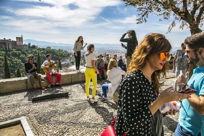 Turistas contemplando la Alhambra desde el mirador de San Nicolás, en Granada.